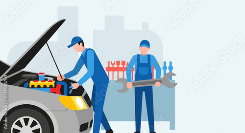 Two mechanics in blue overalls working on a car engine with the hood open, one holding a wrench.