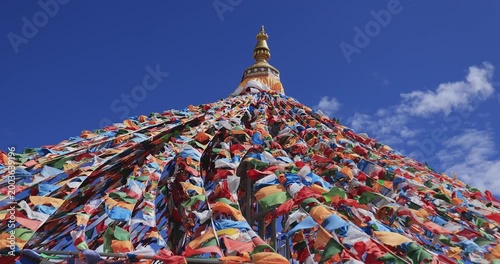 The Changqing Chunker Temple  in Litang, China. Many colourful prayer flags on the mountain top beside the temple.Spirituality and meditation.
