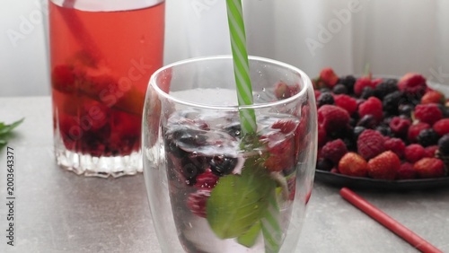 Summer drinks, colored cocktails on table. Lemonade, mojito, strawberry lemonade, tonic water. A refreshing summer drink with raspberries and blueberries, a detox drink for weight loss and keeping fit