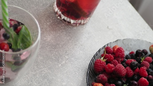Summer drinks, colored cocktails on table. Lemonade, mojito, strawberry lemonade, tonic water. A refreshing summer drink with raspberries and blueberries, a detox drink for weight loss and keeping fit
