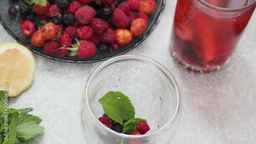 Summer drinks, colored cocktails on table. Lemonade, mojito, strawberry lemonade, tonic water. A refreshing summer drink with raspberries and blueberries, a detox drink for weight loss and keeping fit