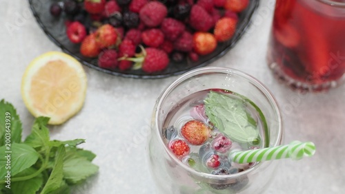 Summer drinks, colored cocktails on table. Lemonade, mojito, strawberry lemonade, tonic water. A refreshing summer drink with raspberries and blueberries, a detox drink for weight loss and keeping fit