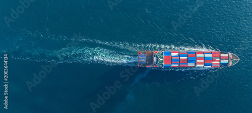 Canvas Print large cargo container ship fully loaded with colorful containers sailing through the deep blue ocean