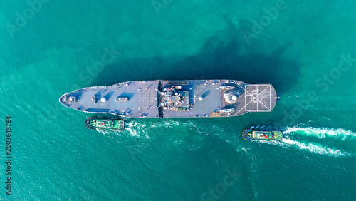 Konstfotografi large naval amphibious assault ship being assisted by tugboats in the strategic Strait of Hormuz