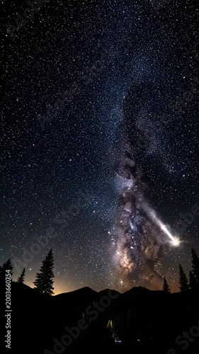 Watch a shooting star pass through the night sky above the mountains in a clear and starry atmosphere