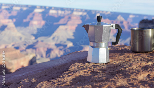 Moka pot espresso maker and metal cup on a rock overlooking the Grand Canyon