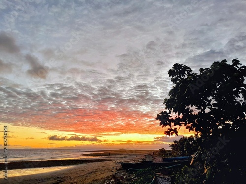Foto Dramatic sunset over the sea, calm ocean with a peaceful tropical shoreline view