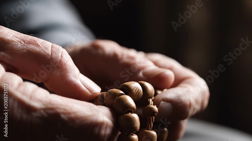 Senior person hands holding wooden prayer beads for meditation and prayer