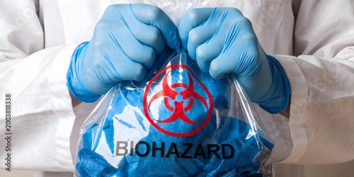 Scientist Holding Biohazard Bag with Protective Gloves Representing Medical Safety Hazard Control Infection Risk and Laboratory Protection Concept