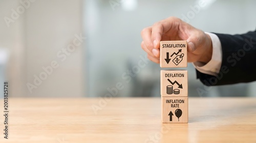 Businessman placing wooden block with stagflation concept on top of deflation and inflation rate blocks on desk in office