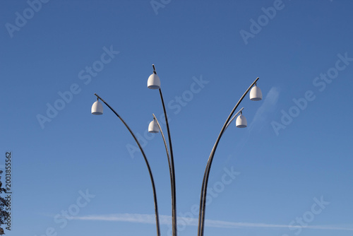 Bild auf Leinwand Modern street lamp design with five curved arms and white shades against a clear