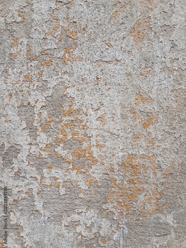 Fototapeta premium Old concrete wall, damaged, uneven structure, with remnants of yellow paint, vintage background for design