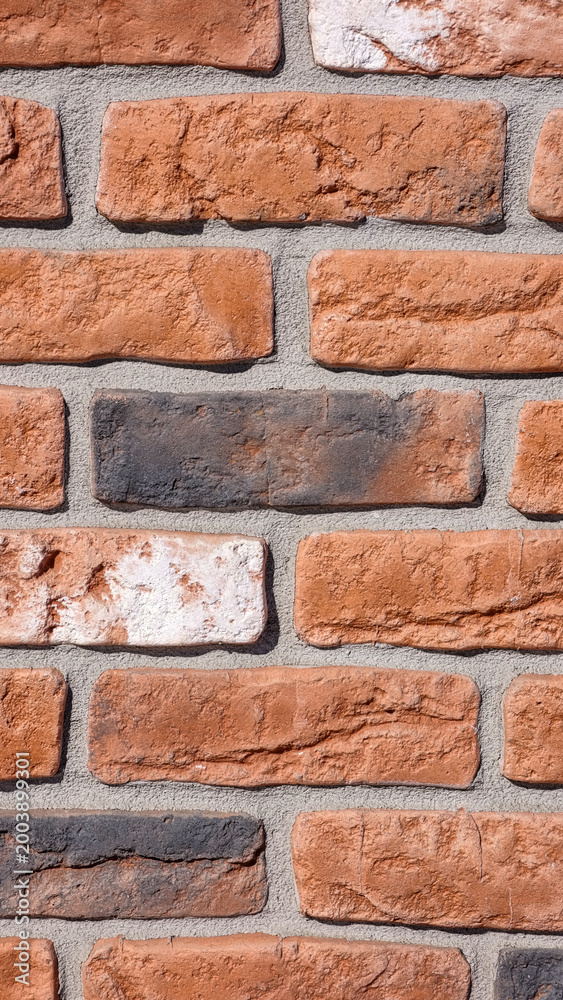 Fototapeta premium Brick wall texture with detailed red brown bricks, gray mortar and realistic surface imperfections. Ultra high resolution 8K background for design, branding and mobile wallpaper use.