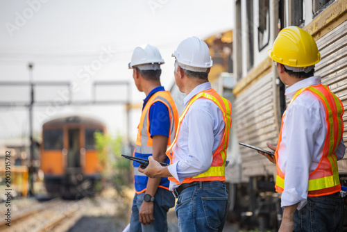 Εκτύπωση καμβά Group of railway engineers in safety vests using walkie-talkie and tablet for tr