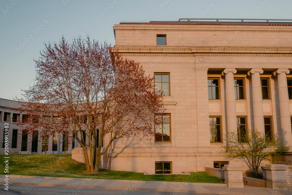 Obraz premium Historic government building with columns during golden hour.