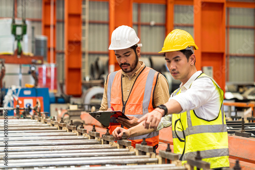 Technicians and foremen are operating machinery in a sheet metal factory.