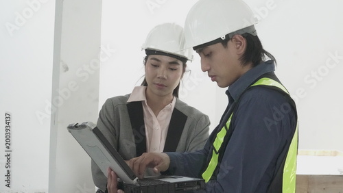 Engineers and architect discussing house model at construction site