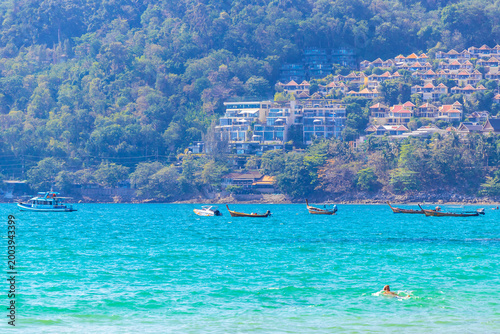 Foto Thai longtail boats floating on turquoise sea near tropical islands