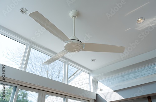 White modern ceiling fan with three blades in a bright, airy room