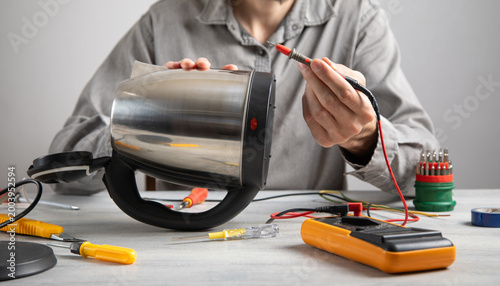 Technician repair broken electric kettle.