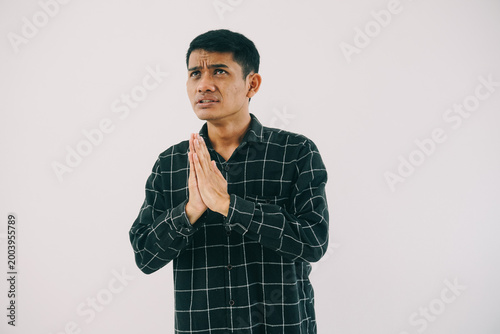 Принти на полотні a man wearing a black and white plaid shirt with his hands clasped together