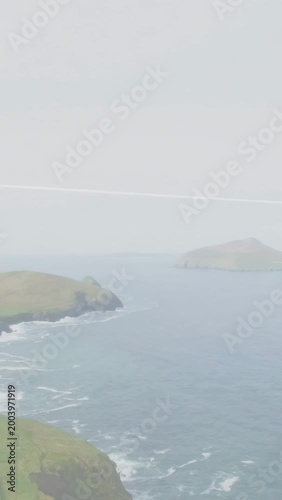 Vertical video: Camera starting slow pan, cliff and sea shifting, dark band crossing revealing sea