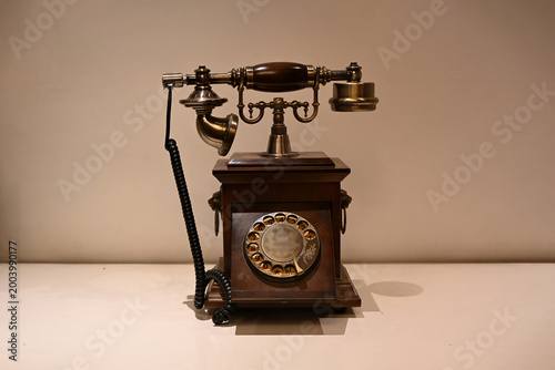 A classic vintage telephone featuring a wooden base and a traditional rotary dial