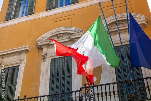 Photography Drapeau italien et européen sur un mur ocre de la ville de Rome, Italie