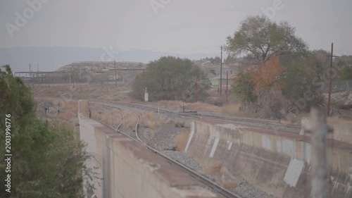 Railroad Tracks Curving Along Concrete Channel in Industrial Landscape