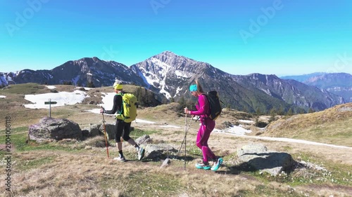 Couple Hiking in Mountain Landscape with Snowy Peaks
