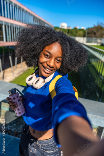 Smiling young woman student making a selfie on campus