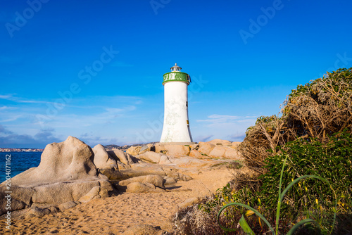 Sunny panoramic view of Punta Palau Lighthouse with sandy Feraglione beach on Sardinia Island, Italy