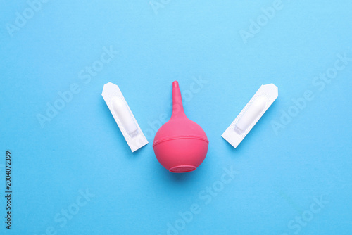 Foto Rectal suppositories and enema on blue background