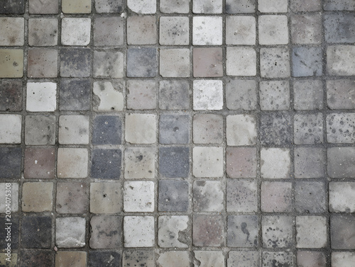 Close view of sidewalk tiles showing different colors and textures in a city area during daylight