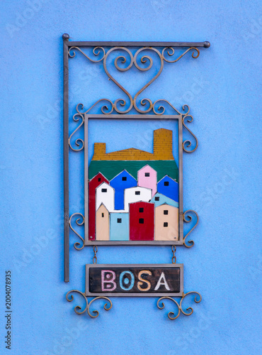 Colorful Bosa city sign on a blue wall, Sardinia Island, Italy