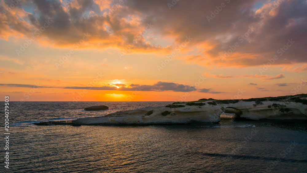 Obraz premium Sunset view of S'Archittu arch-shaped rock, forged by the sea and wind in S'Archittu village, Sardinia Island, Italy