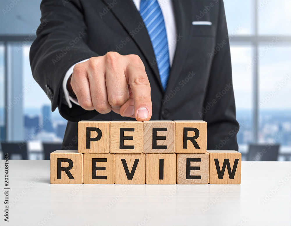 Obraz premium Peer Review - Geschäftsmann zeigt auf den Text 