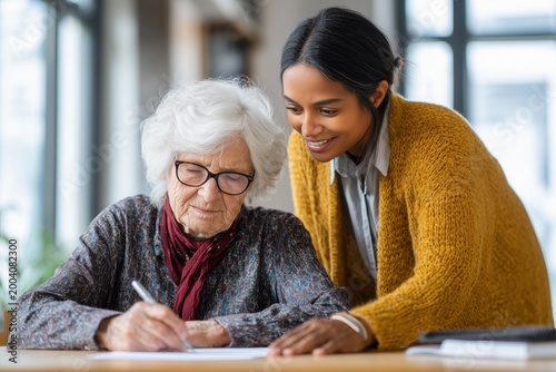 Caring young law student volunteer helping elderly client with legal documents at community clinic explaining paperwork with patience pro bono service and support portrait