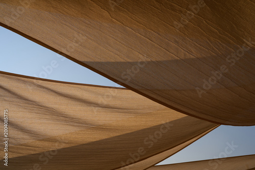 Schilderij op canvas Geometric beige shade sails against blue sky at Fuxian Lake, Yunnan