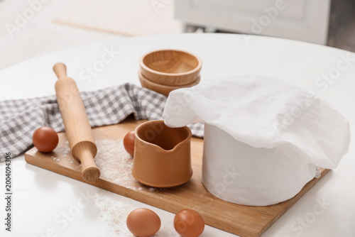 Chef's hat, eggs and utensi...