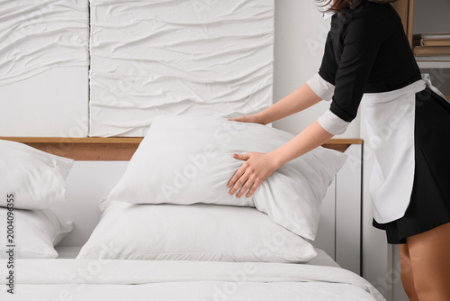 Young chambermaid putting s...