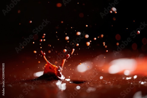 Detailed Macro Photograph Of Vibrant Red Paint Spraying Over Textured Background With Dramatic Lighting