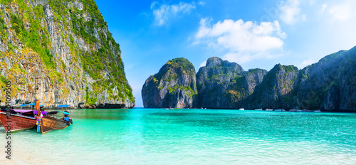 Wide Tropical Beach Scene in Maya Bay, Phi Phi islands in Thailand. Panoramic view of sandy beach with longtail boat and turquoise lagoon in Maya Bay in Thailand