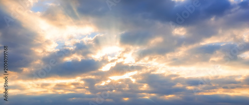 Cloudy sky with sun rays breaking through. Atmospheric natural background suitable for weather, spirituality and dramatic visual concepts.