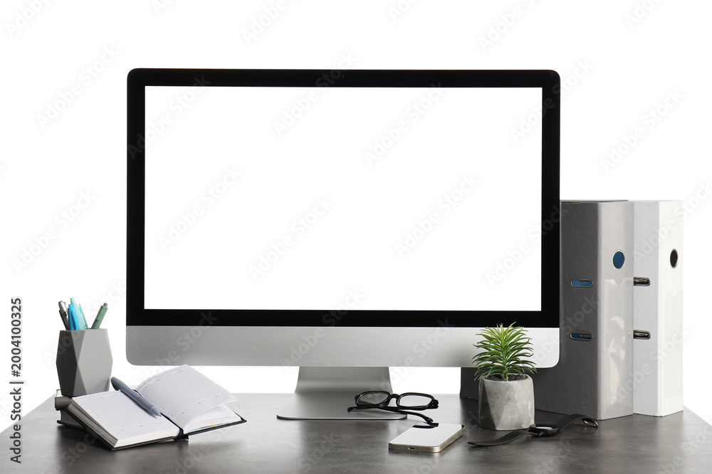 Fototapeta premium Table with blank computer monitor, mobile phone and eyeglasses isolated on white background