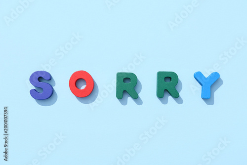 Fotografia Word SORRY made from colorful letters on blue background