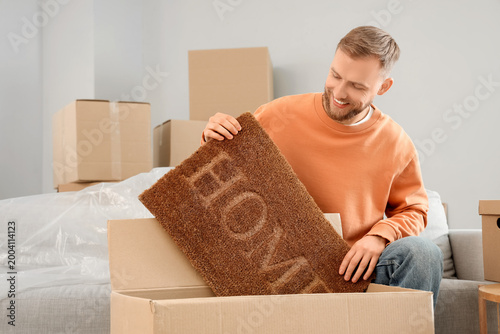 Young man taking doormat ou...