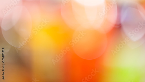 Warm bokeh background with soft orange yellow and pink defocused light circles for dreamy backdrop