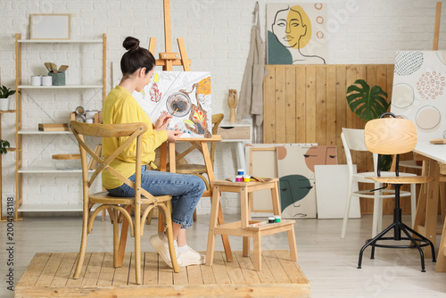 Young woman painting by num...