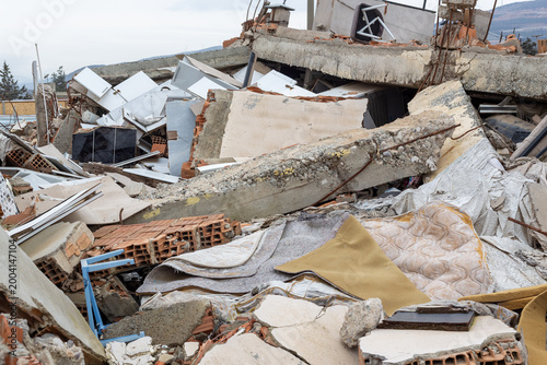 Severe destruction after a major earthquake in Turkey. Concrete debris, bricks, and household items scattered in ruins. Disaster relief and emergency recovery efforts. disaster of the century.